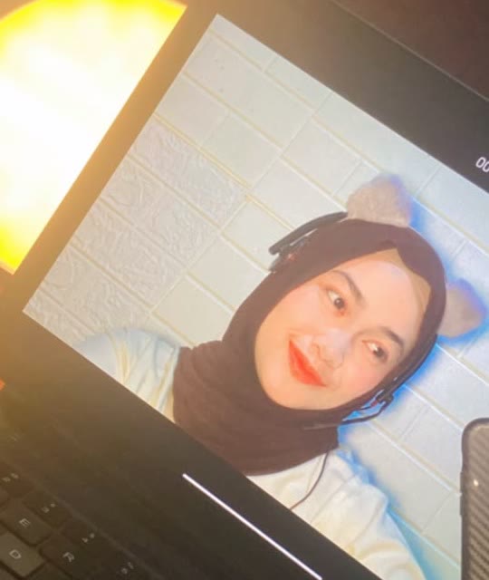 Teacher Dila smiling, ready for an online class